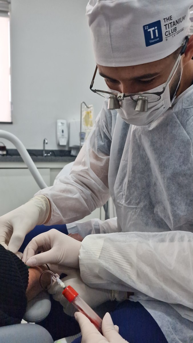 Docente com lupas durante colheita de sangue para PRF